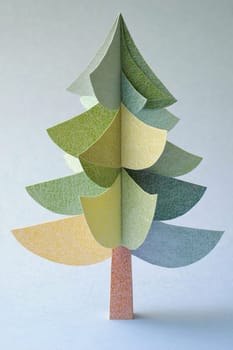 An artistic representation of a tree made from layered paper, displaying various shades and textures in a creative arrangement.