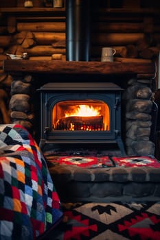 A warm fire burns in a stone fireplace, surrounded by rustic decor and a colorful quilt, creating a cozy atmosphere indoors.