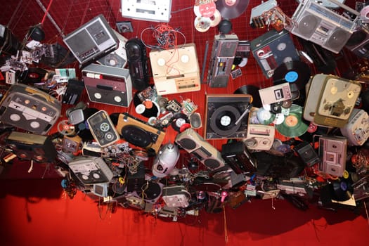 Venice, Italy - May 7 2024: Foreigners Everywhere 60th Venice Art Biennale. John Akomfrah, Listening All Night To The Rain at British Pavilion. Old video and audio players hanging from the ceiling of the red room.