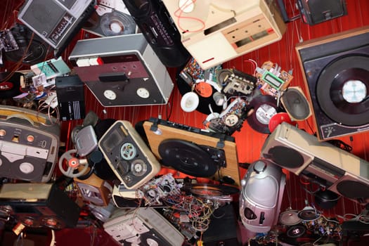 Venice, Italy - May 7 2024: Foreigners Everywhere 60th Venice Art Biennale. John Akomfrah, Listening All Night To The Rain at British Pavilion. Old video and audio players hanging from the ceiling of the red room.