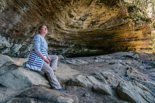 Female hiker taking rest in a small grotto in Red River Gorge in Kentucky