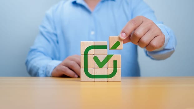 Businessman select green correct sign mark print on wooden block for approve business project proposal concept. Goals achievement and business success. Task completion. Ethical corporate.