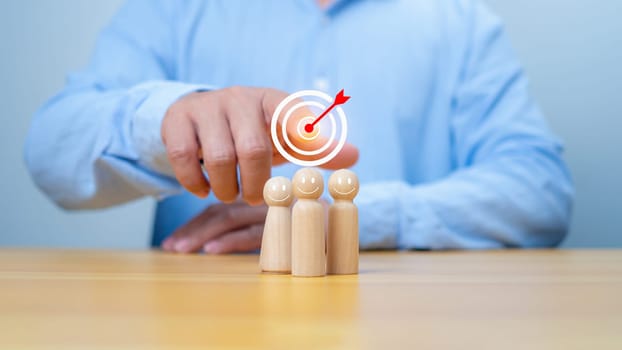 Business achievement goal and objective target, Team growing business success concept, Teamwork, Successful team, Hand holding dartboards target and human icon with line connection on wooden block.