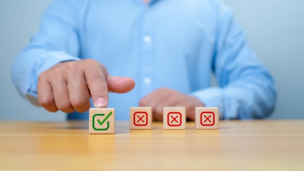Businessman select green correct sign mark print on wooden block for approve business project proposal concept. Goals achievement and business success. Task completion. Ethical corporate.