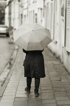 Woman with umbrella in rainy weather in the old town of Bruges in Belgium