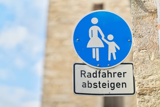 Sign in a pedestrian zone with the German inscription Radfahrer absteigen. Translation: cyclists dismount