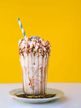 front view delicious milkshake with yellow background. High resolution photo