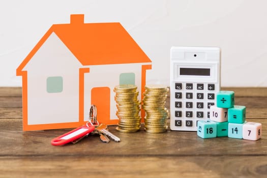house key stacked coins calculator math blocks wooden table. High resolution photo