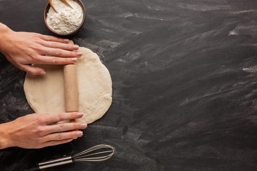 hands rolling bread dough with whisk. High resolution photo