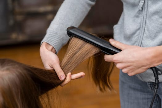little girl getting her hair straightened. High resolution photo
