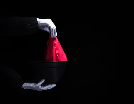 magician s hand performing magic trick with napkin top black hat. High resolution photo