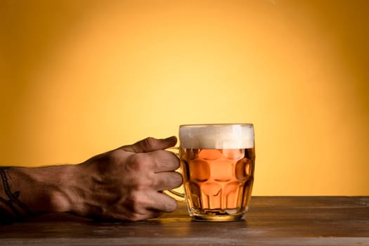 man holding glass beer wooden table. High resolution photo