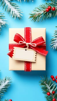 A beautifully wrapped gift box with a red ribbon and snowy sprigs on a blue background, perfect for winter celebrations.