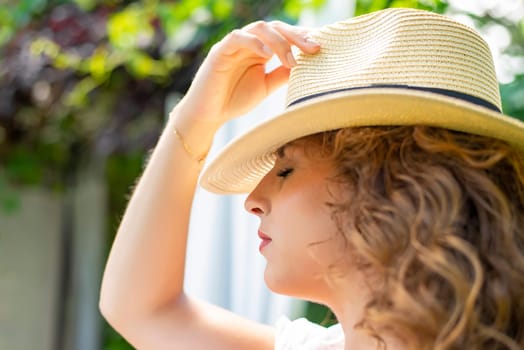 thoughtful young woman with straw hat enjoying the sun in the garden