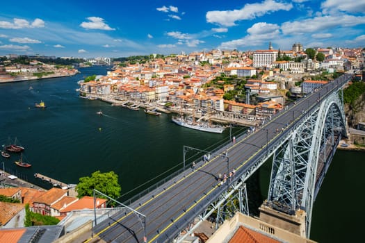 View of Porto city and Douro river with moored sailing ship and Dom Luis bridge I from famous tourist viewpoint Miradouro da Serra do Pilar on sunset. Porto, Vila Nova de Gaia, Portugal