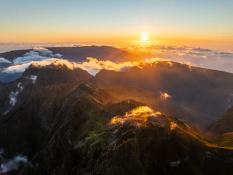 Aerial drone view of mountains over clouds near Pico Ruivo on sunset. Madeira island, Portugal
