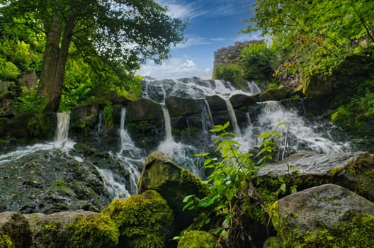 Small waterfall in Sweden. Moss-covered stones. Forest on the river bank. Scandinavian nature