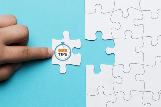 close up person touching white puzzle with quick tips text stop watch clock. High resolution photo