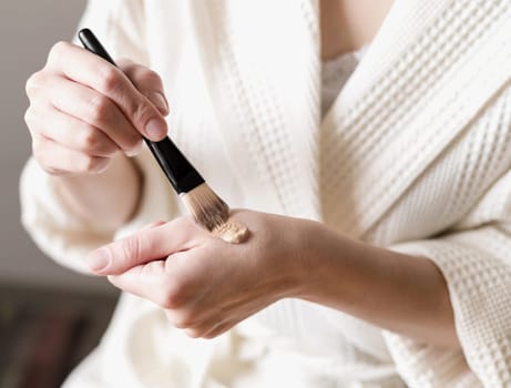 close up foundation applied hand with brush. High resolution photo