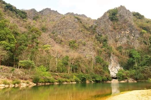 View from the shore, beach of the river onto the entrance of the Kong Lor Cave, a tourist attraction on the Thakhek Motorbike Loop, Laos 2023