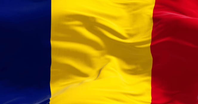 Close-up of Chad national flag waving in the wind on a clear day. Vertical tricolor of blue, gold, and red. 3d illustration render, fluttering fabric.