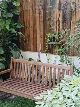 A charming garden area with rustic wooden benches and a table surrounded by lush greenery, creating a peaceful and inviting outdoor space.