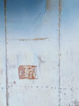 Close-up of a weathered metal surface featuring subtle blue grey gray hues, rust patches, and unique textures. Perfect for backgrounds or industrial-themed designs highlighting age and character.