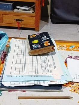 A vibrant desk setup featuring notebooks, pens, and creative supplies. A colorful pencil case and decorative journal indicate a fun and organized workspace. Ideal for studying or creative projects.