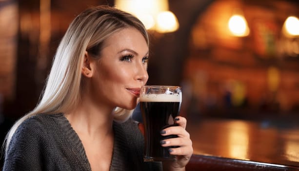 gorgeous young woman in british pub drinking beer, AI generated image
