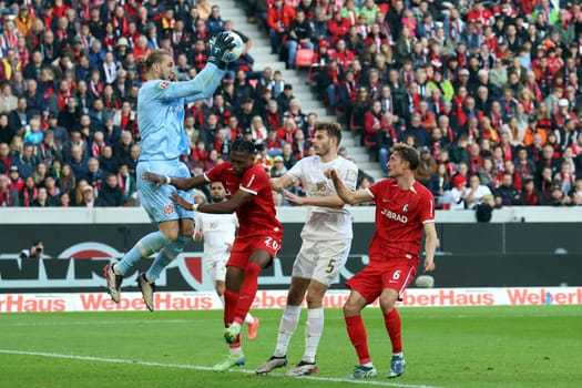Saved what could be saved: Goalkeeper Robin Zentner (FSV Mainz 05),clears in front of Junior Adamu (SC Freiburg) and Patrick Osterhage (SC Freiburg),Maxim Leitsch (FSV Mainz 05) no longer needs to intervene in the game of the 1st FBL: 24-25: 1st FBL: 24-25: 9th Sptg. SC Freiburg - FSV Mainz 05  DFL REGULATIONS PROHIBIT ANY USE OF PHOTOGRAPHS AS IMAGE SEQUENCES AND/OR QUASI-VIDEONann  Photo: Joachim Hahne/johapress