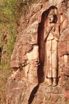 A Sandstone Buddha Rock Sculpture carved into the rock along the road on the Thakhek Motorbike Loop, Laos 2023