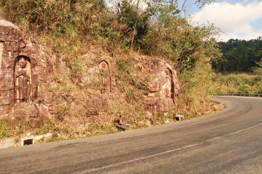 The winding, windy road leads along some Sandstone Buddha Rock Sculptures on the Thakhek Motorbike Loop, Laos 2023