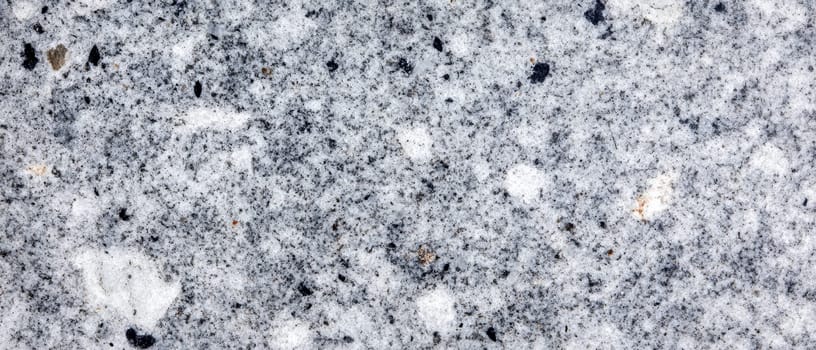 Detailed close up of gray granite surface showing natural patterns, speckles, and crystalline structure of the stone.