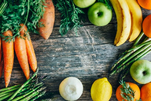 Healthy bio food ingredients frame background from above. Top view of organic superfood border on rustic wooden table. Colorful fruits and vegetables overhead.