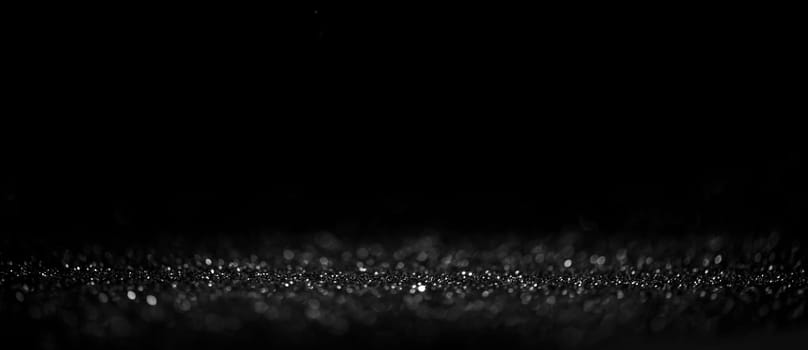 Black friday bokeh background. Elegant dark blur layout design. Silver and black glitter place on table with spotlight. Luxury abstract banner with copyspace.