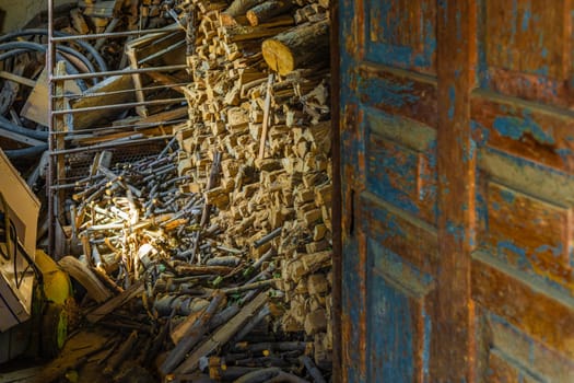 barn with chunks of firewood behind old shabby door