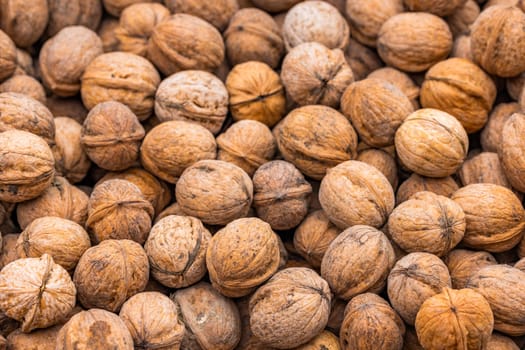 pile of unpeeled walnuts, closeup macro background with selective focus