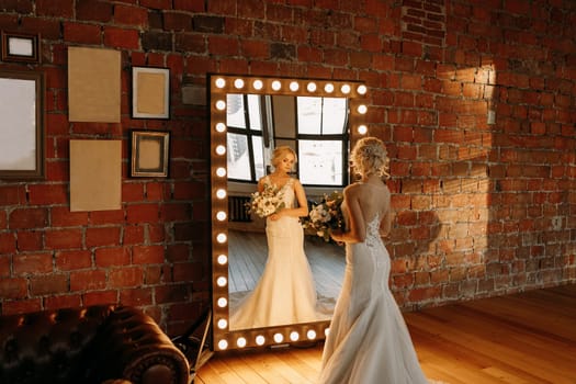 A stunning bride in a beautiful gown takes a moment to admire her reflection just before the ceremony starts