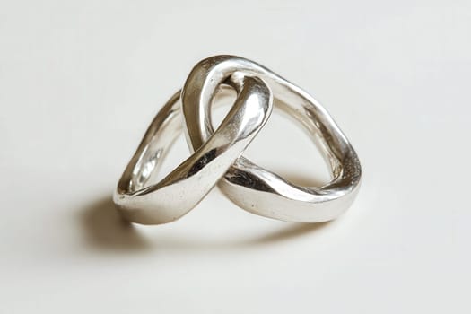 These elegant intertwined wedding rings represent a timeless bond between two individuals. Crafted with precision, they embody love and commitment on a special day celebrating unity.