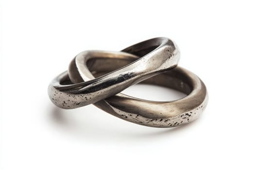 A pair of intertwined wedding rings rests elegantly, representing everlasting commitment and romance. The rings smooth, metallic surface gleams softly in the light, enhancing their connection.