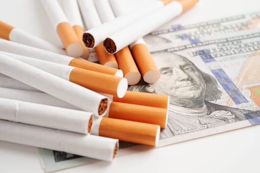 Cigarette on US dollar banknotes, cost, trading, marketing and production, No smoking concept.