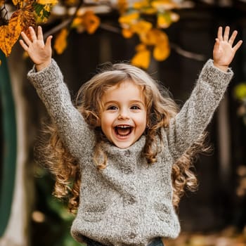 Smiling girl in a cozy sweater, arms raised in excitement, surrounded by autumn leaves and warm colors.