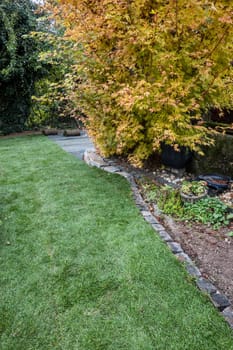Rollrasen wird im Garten auf einer Matte zum Schutz vor Wühlmäusen verlegt