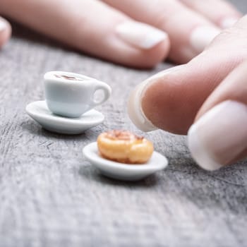 Tiny coffee cup and pastry convey the dissatisfaction of restrictive diets, intolerance, and cost issues. Lack of time further emphasizes the missing fulfillment in morning routines