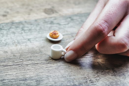 microscopically small coffee and pastry reflect limitations in breakfast due to diet, sugar control, lactose and gluten intolerance, cost, and time. This evokes feelings of unfulfilled morning rituals