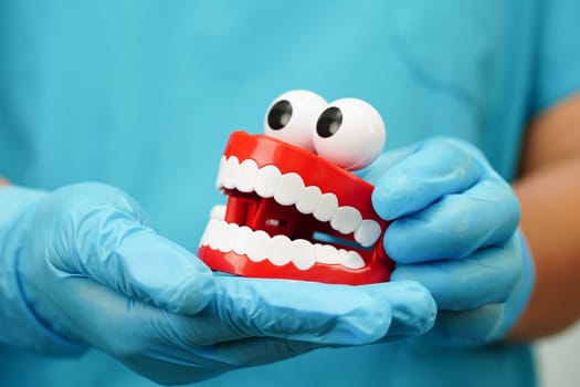 Funny red teeth with eye toy denture model for dental health care.