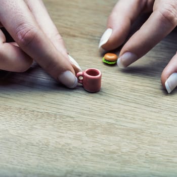 tiny coffee and burger emphasize portion controls challenge. Although accurate, they appear too small, highlighting how difficult dietary discipline can feel when applied consistently