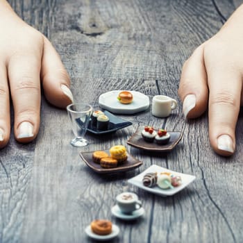 Miniature sushi, coffee, and pastries remind us that nutritional portions often appear insufficient. Despite their delicious appearance, these temptations require discipline to be satisfying
