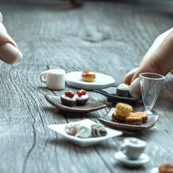 Miniature versions of sandwiches, sushi, and coffee remind us that nutritional portions may feel unsatisfying. Visually appealing, these tiny servings challenge discipline in indulgence