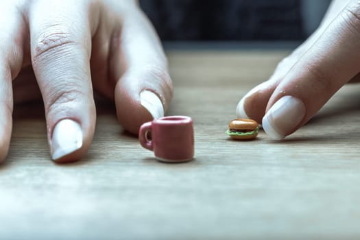 Small portions like this burger and coffee represent nutritionally accurate servings. Despite their visual appeal, they seem unsatisfying, reminding us of the discipline needed for diet adherence